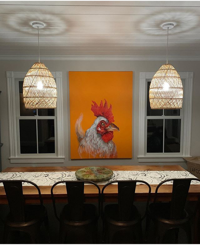 a large painting of a rooster by Dana Ellyn in a dining room setting